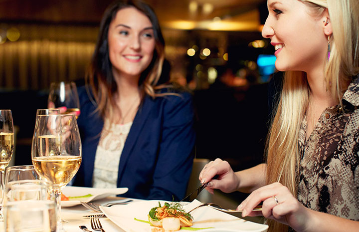 Två personer siter och äter mat och har det trevligt